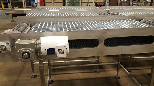 A set of stainless steel conveyors with rollers, featuring motors and components designed to replicate an existing conveyor line, built for a major beef processor.