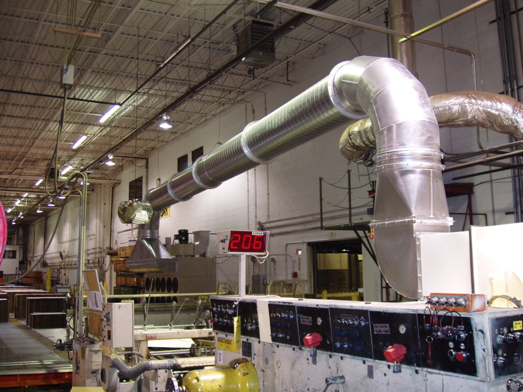 Industrial workspace with a large ventilation duct, control panels, and a digital display reading "206".